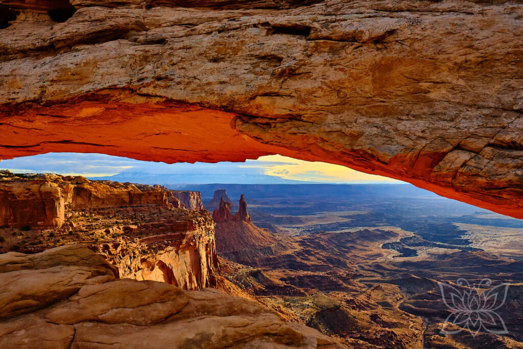 Mesa Arch, Canyonlands, USA bei Sonnenaufgang und Blick über die darunter liegende Schluchtlandschaft