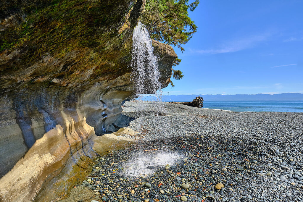 Waaserfall von einer Klippe am Strand