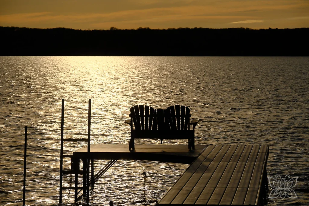 Stühle auf Steg im Sonnenuntergangslicht am See