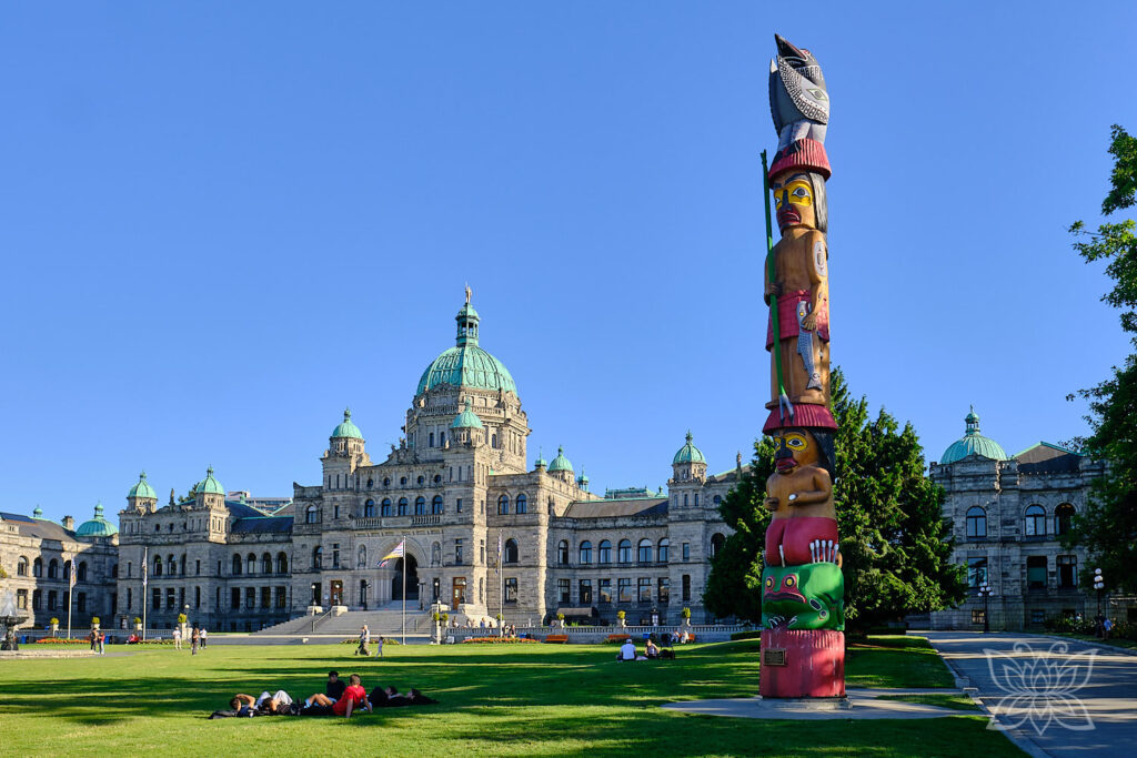 Historisches Gebäude in Victoria mit Totempfahl im Vordergrund