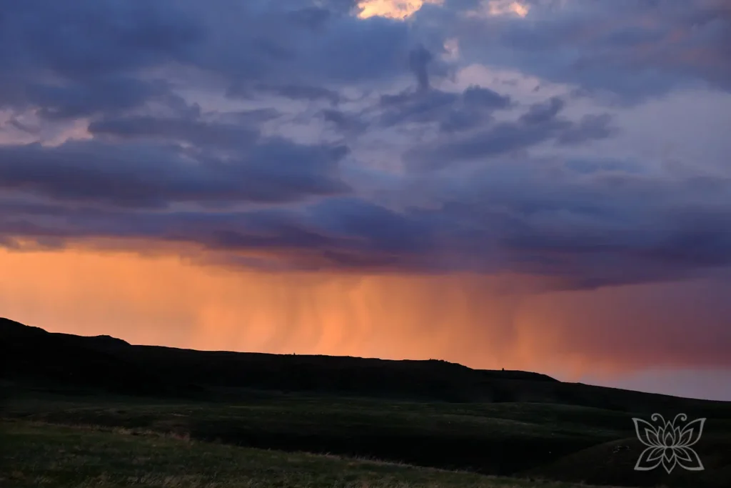 Wolken im Abendlicht, so dass der Regen orange leuchtet