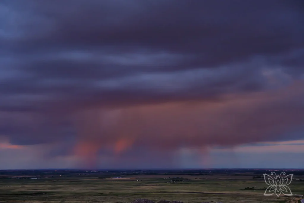 Regenwolken im Abendlicht über der Prärie