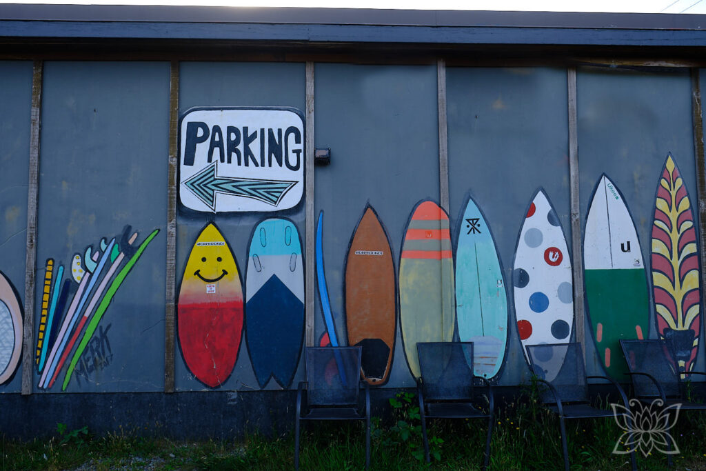 Parkhinweisschild mit lauter bunten Surfboards an einer Hauswand