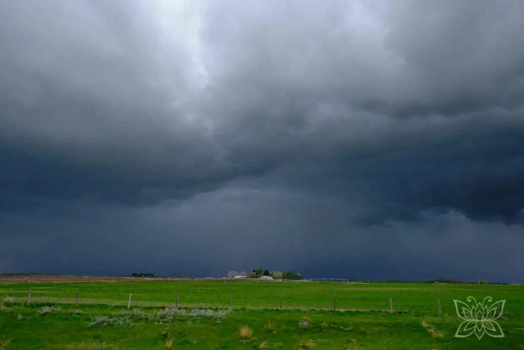 Dramatische Regenwolken im Westen Kanadas mit Gehöft in der Ferne