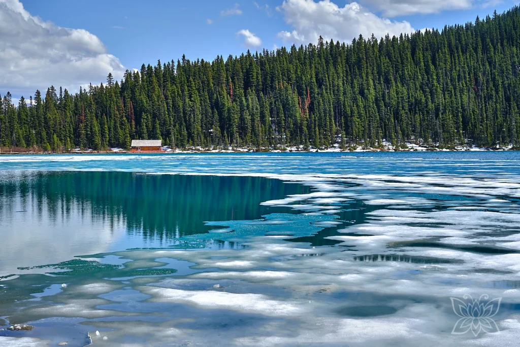 Eisschollen auf dem Lake Louise mit Hütte im Hintergrund