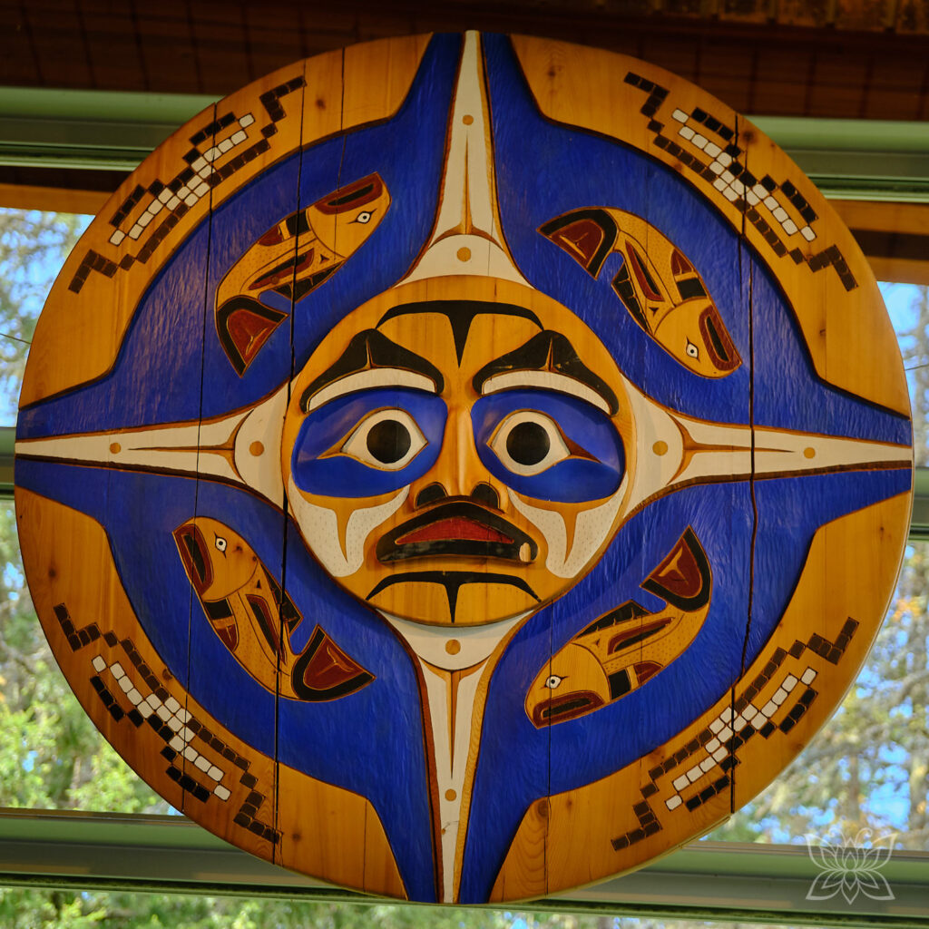 Ausstellungsstücke von großen bemalten Holzscheiben im Squamish_Lil`wat Cultural Centre