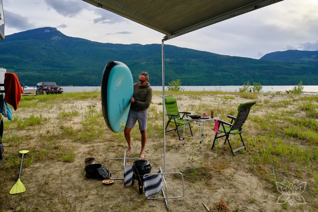 Jörg mit SUP unter dem Arm an unserem Campspot