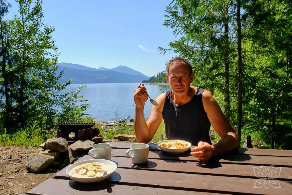 Jörg beim Früstück an einem Picknicktisch am See