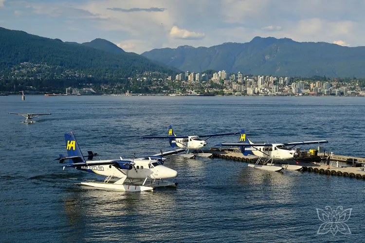 Wasserflugzeuge im Hafen vor Stadt- und Bergkulisse