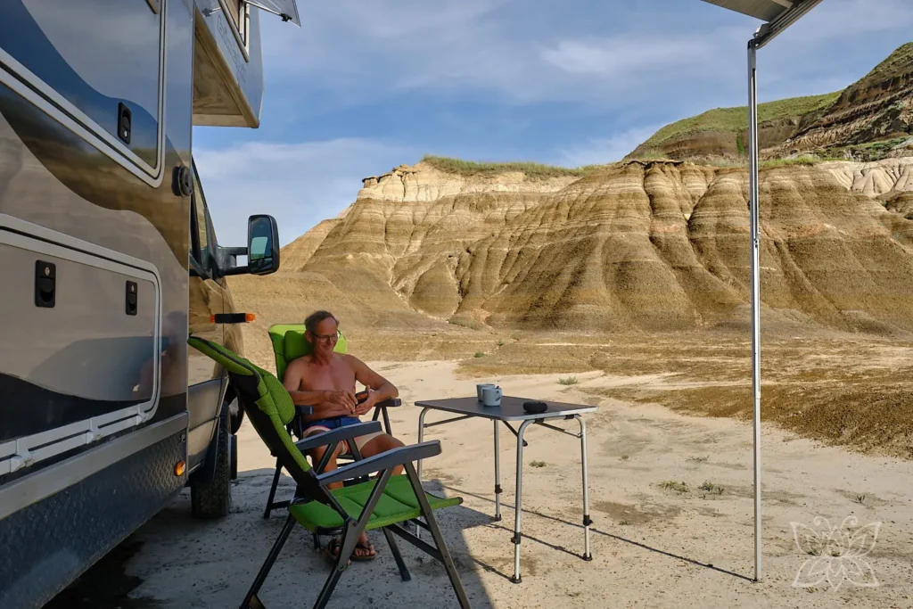 Jörg sitzt vor Balu mit Blick auf die Sandsteinformationen